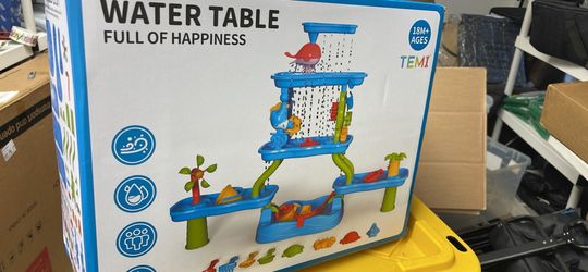 New water table in box. It is a TEMI brand water table for 18 months and up. Water table has multiple play levels, water slides, water wheels, and var