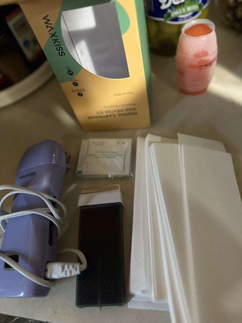 2 filled bottles of wax Alot of wax strips Wax removal pads And its a plug in wax heater Brand new 
