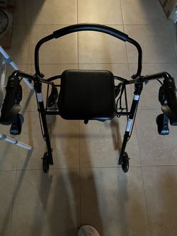 Rollator with four wheels, brakes