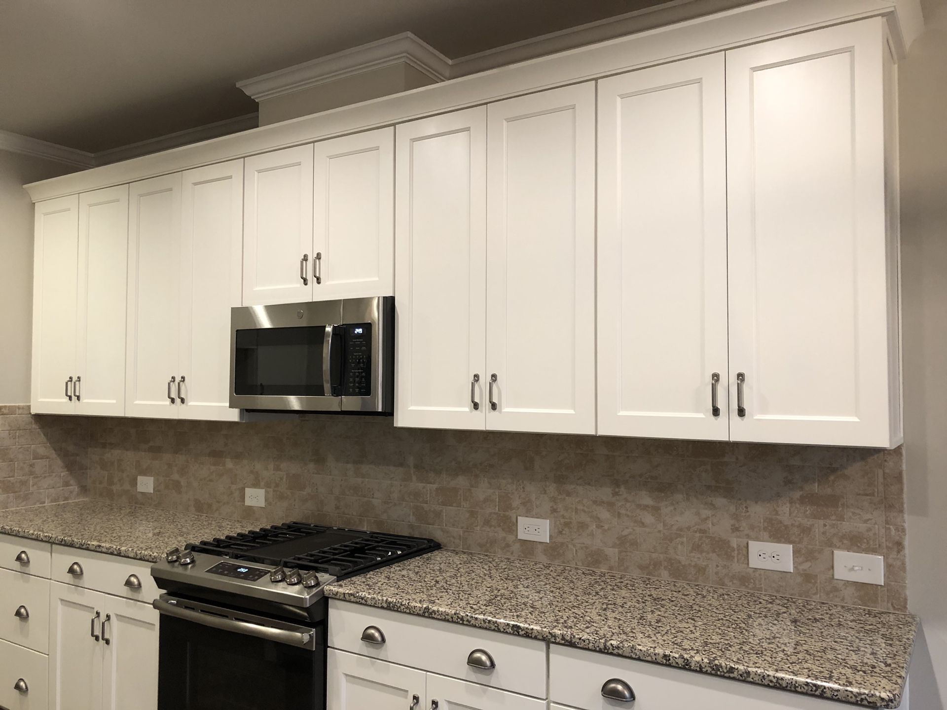 Complete Norcraft Kitchen Cabinetry with granite countertops, microwave, crown molding, island and pendant lights included