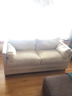Large white suede couch with a pull out full size bed