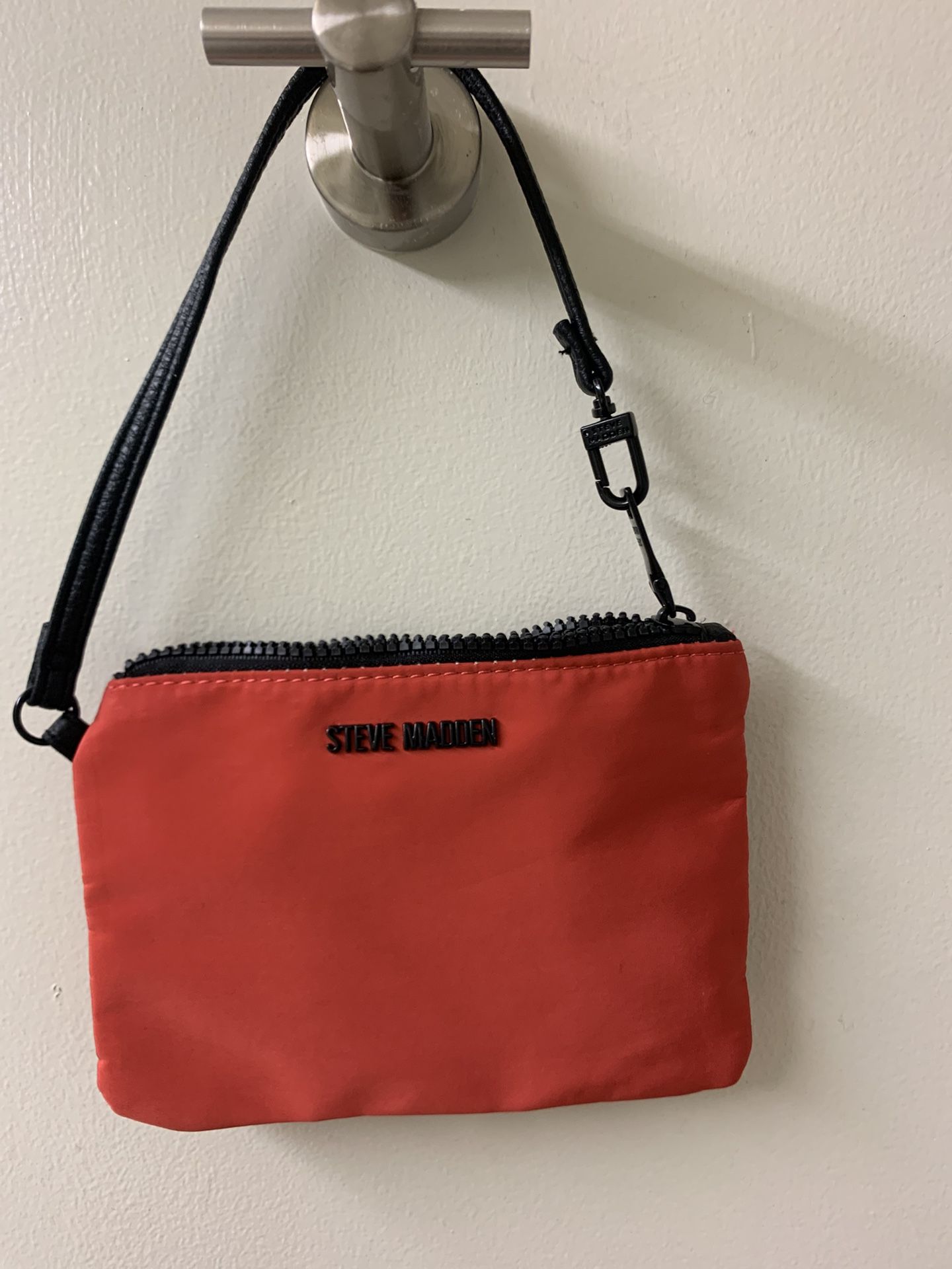 Red clutch (cosmetic bag or purse bracelet) Steve Madden with a black strap.