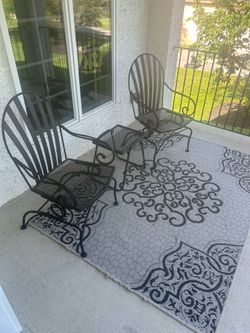 Black iron chairs, table and rug