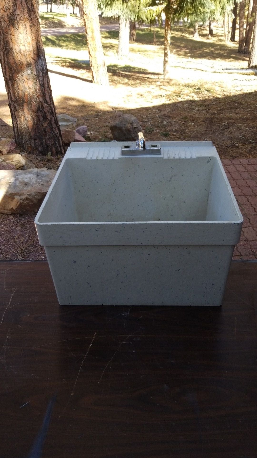 Laundry room utility sink with wall mounting bracket