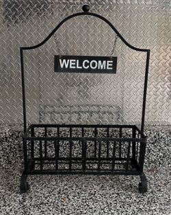 Black metal planter stand with hanging "WELCOME" sign