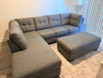 Gray three piece sectional sofa and ottoman