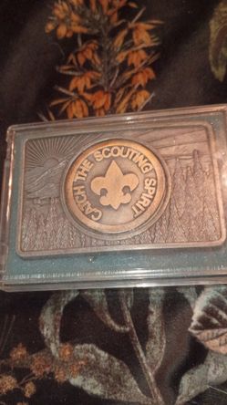 This item is a vintage Boy Scouts of America (BSA) "Catch the Scouting Spirit" pewter belt buckle, which served as the organization's annual program t