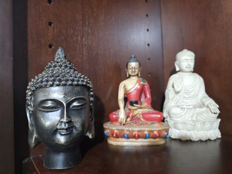Set of three Buddha statues in various styles and colors.