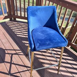 Blue velvet upholstered counter stool with polished gold metal legs and footrest. Excellent condition. Height: counter height. Sells fast—grab it!