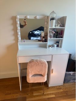 Vanity desk with organizers and a fur chair.