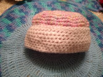 Hand crafted crocheted hat. Hand made with pink yarn on top and white yarn on bottom base cream with
