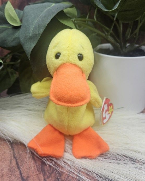 TY nwt Beanie Baby Quackers yellow duck April 19, 1994 vintage plush toy
Features bright orange beak and feet. Perfect for cuddling.