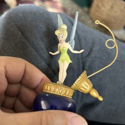 Your Tinker Bell figurine atop a decorative bottle i