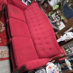 Vintage Louis XV style sofa in red velvet with dark wood trim.

