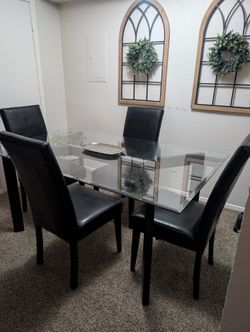 Glass dining room table with black chairs