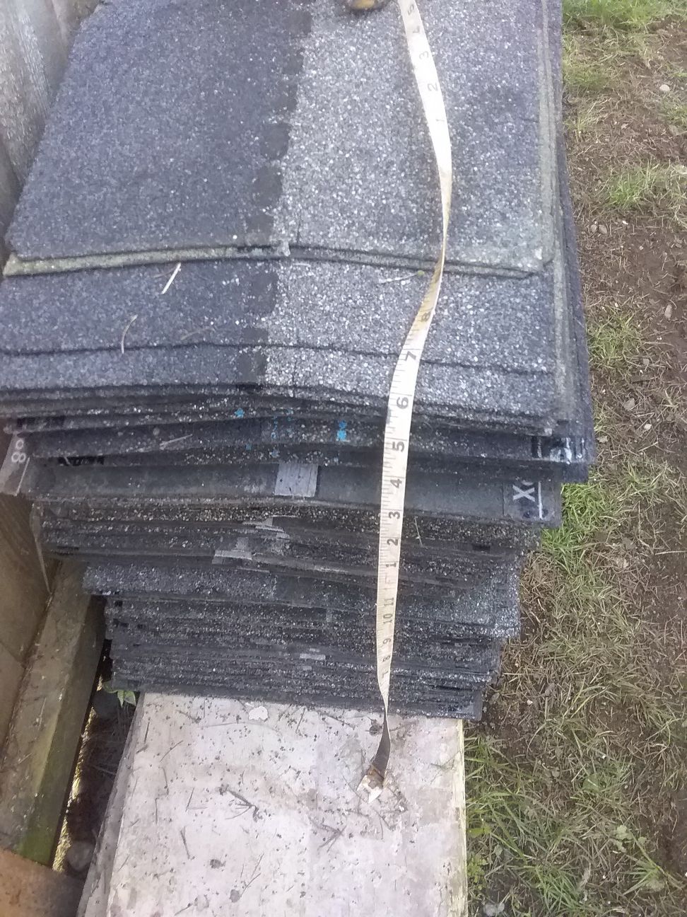 Pile of leftover roofing shingles ridge cap architectural shingles and starter