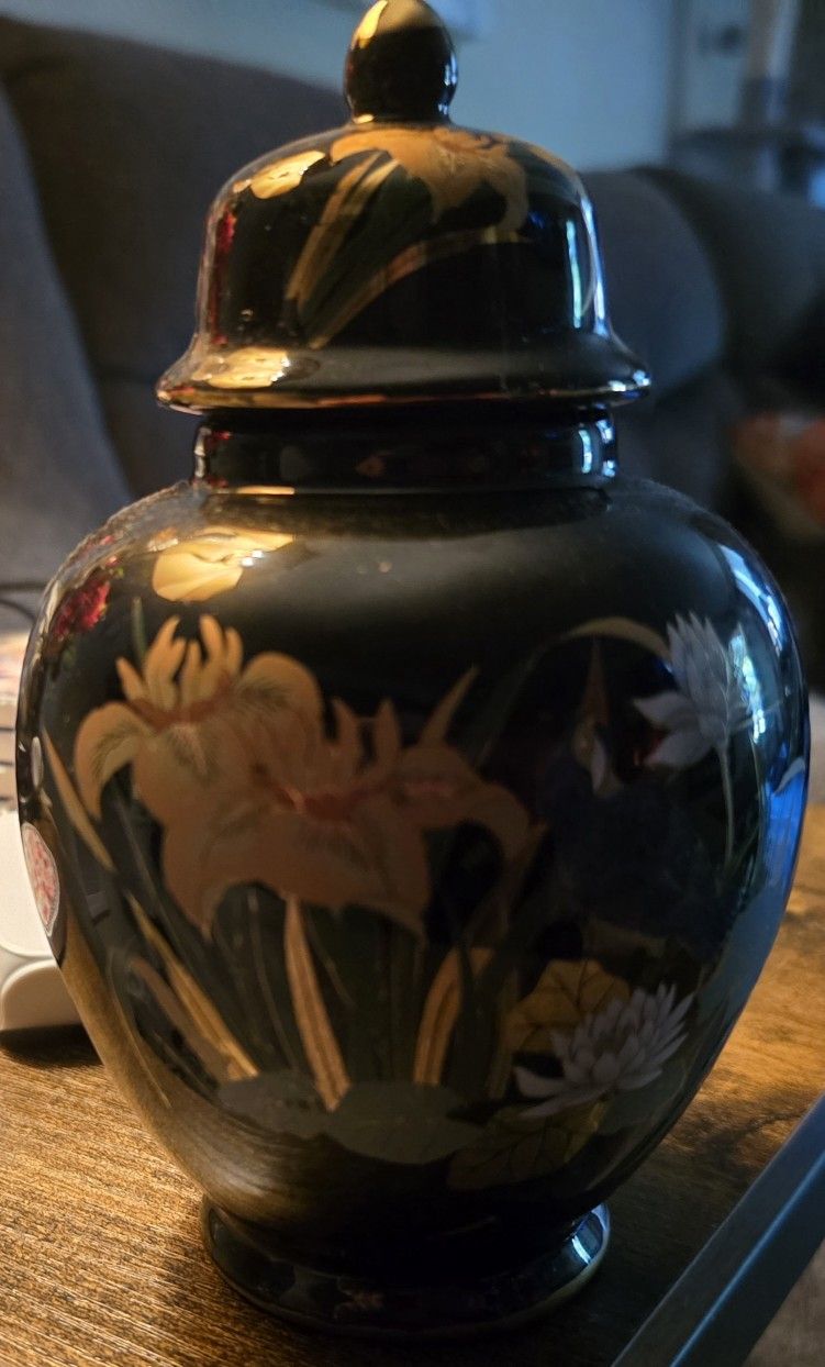 A black porcelain vase with gold floral designs and accents, featuring birds & other elements.