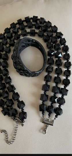 It’s two pieces necklace and bracelet. The color is black.