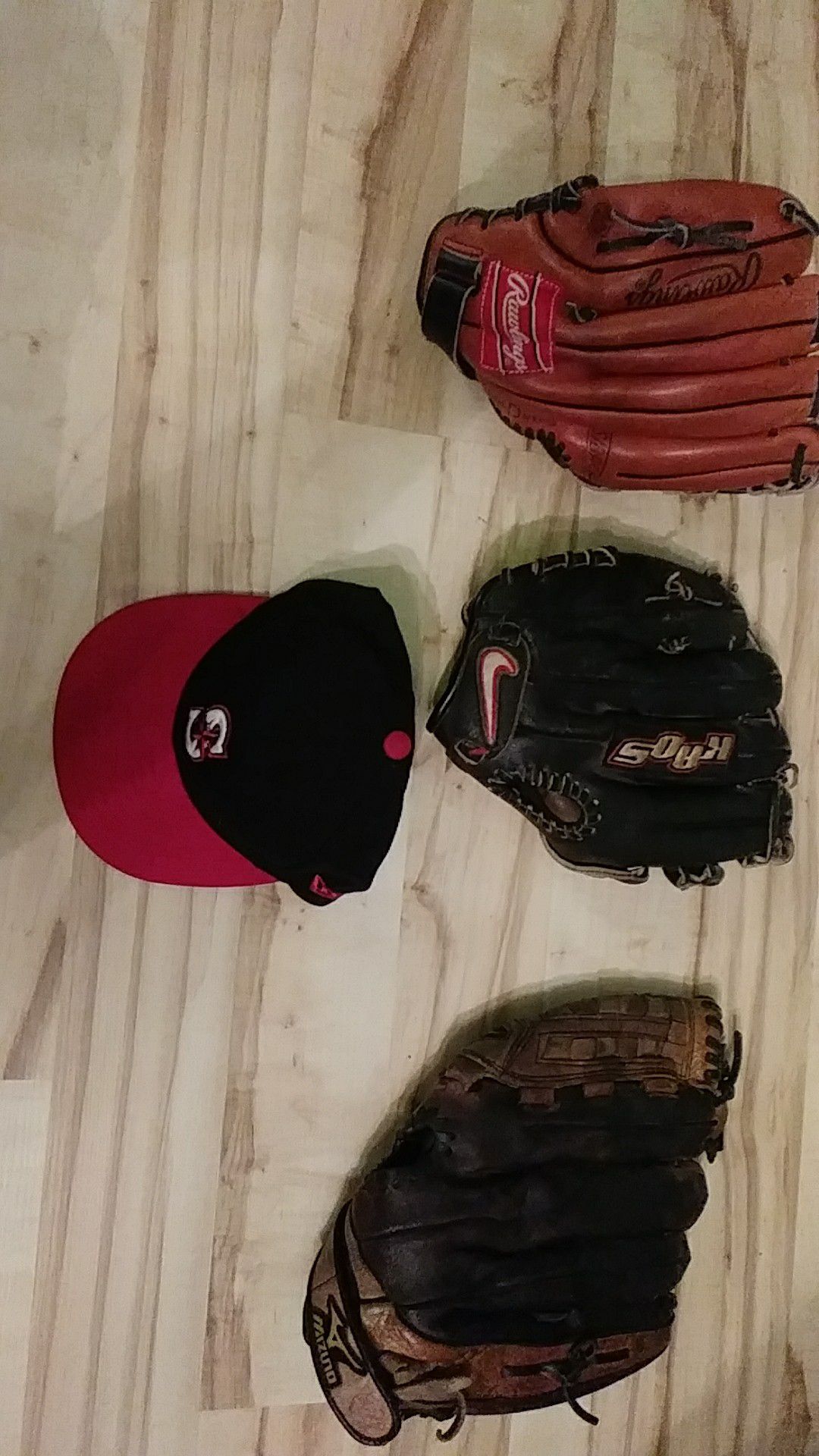 Lot of baseball gloves, Nike Mizuno, Rawlings and Mariners hat