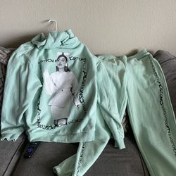 Ariana Grande positions hoodie with matching sweatpants. 
