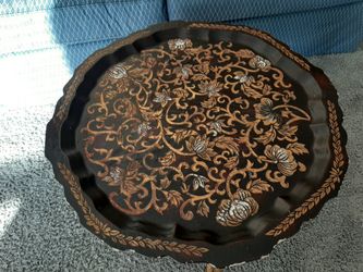 Ornate coffee table with gold etching on bamboo legs.