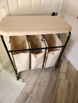 Laundry hamper with ironing board