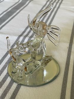 Hand-blown glass figurine of two elephants with gold accents on a mirrored base.