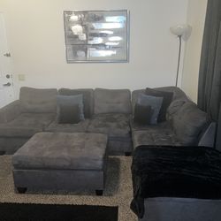 Comfortable Grey Couch With Ottoman and Pillows