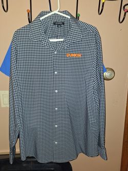 The image shows a Port Authority grey and white micro-check, long-sleeve dress shirt featuring an embroidered Dunkin' logo in orange across the left c