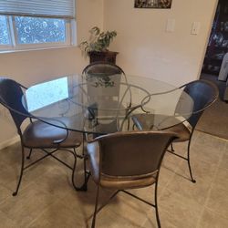 Beveled Glass Table. Iron Frame. Leather Chairs