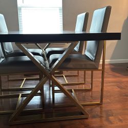 Black Wooden Table With Grey Chairs And Brass Legs 
