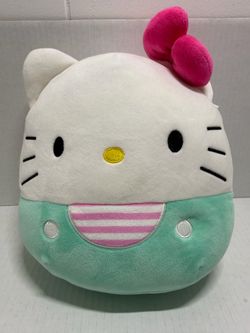 Squishmallows Hello Kitty plush with embroidered details. Soft mint body and white head. Bright pink bow and striped bib accent. Simple, cuddly design