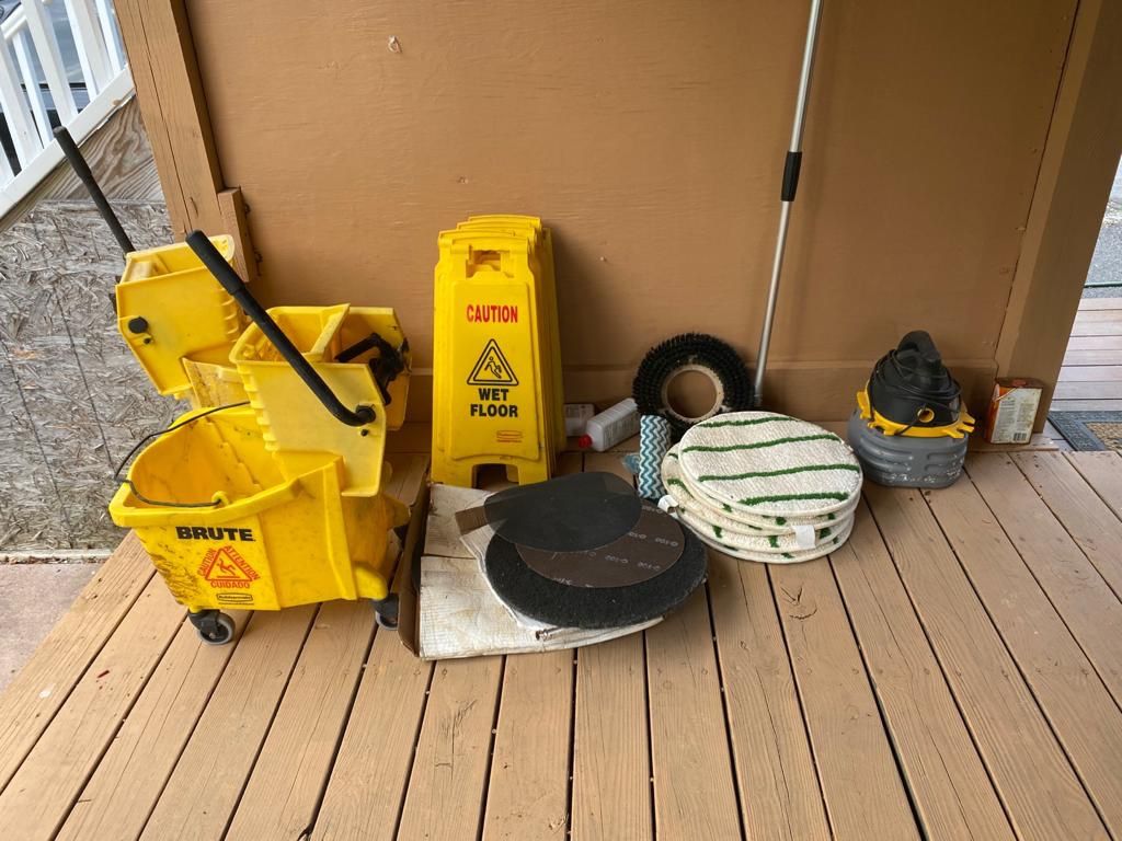 Caution signs, mop buckets, floor cleaning supplies, water suctioning vacuum