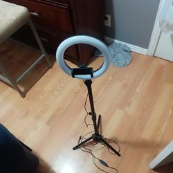 a desktop LED ring light with a tripod stand and phone holder. 
