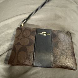 The item in the image is a Coach Corner Zip Wristlet in signature coated canvas with a blue and brown