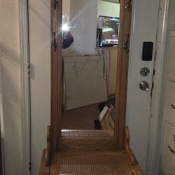 traditional-style wood hall tree with a mirror and storage bench. 