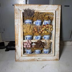 Wooden Frame with Dried botanicals arranged in small blue and white porcelain mini cups