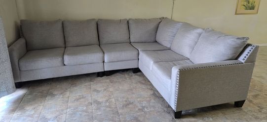 Beautiful sectional couchThis is a gray fabric sectional sofa with nailhead trim detail along the arm.
