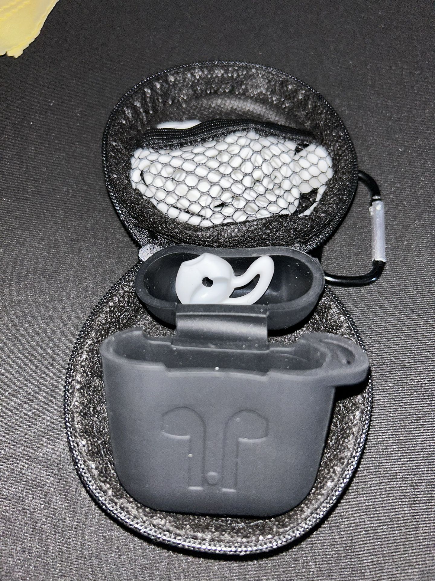 Apple AirPods silicone case, stored within a zippered carrying case.