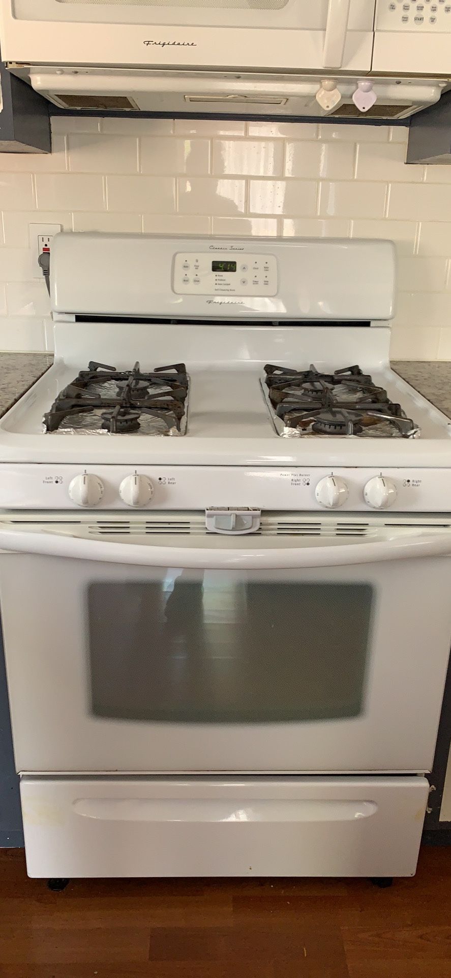 Appliances white gas stove overhead microwave fan.
