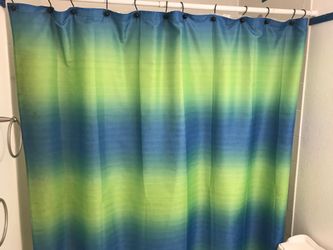 Blue green heavy fabric shower curtain with shower curtain hooks.