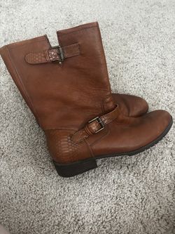 brown leather mid-calf boots with decorative buckle straps and textured, snakeskin-style accents.