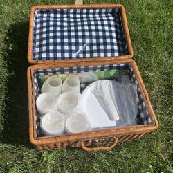 Wicker picnic basket with cups plates and utensils for four