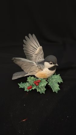 A Lenox porcelain chickadee figurine on a holly base.