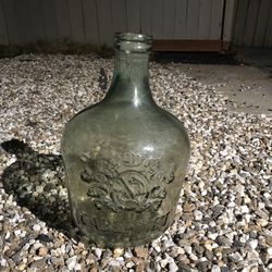 antique green glass demijohn or wine jug with an embossed crest