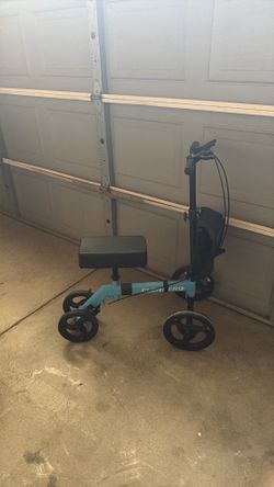 Elenker knee scooter with storage bag in front of bike