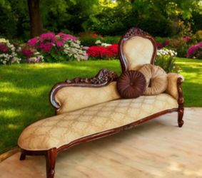 Vintage chaise fainting couch chase lounge features a dark wood frame with intricate carvings and cream-colored patterned damask fabric. Pillows may