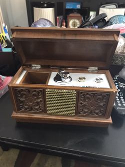 Vintage wooden box with radio and lighter.