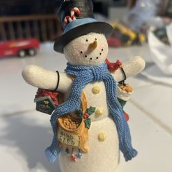 Hallmark 2003 Multicolor Snowman figurine featuring a birdseed bag.  It is made of mixed materials with a frosted glitter finish. The snowman wears a 