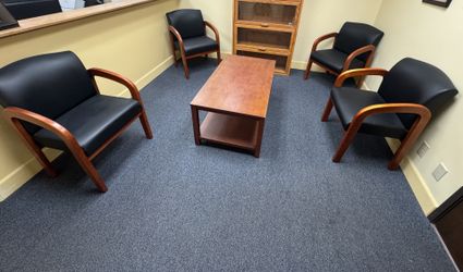 Reception area magazine/coffee table with 4 padded wood arm chairs